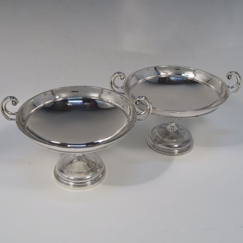 A very handsome and large pair of Antique Sterling Silver bon-bon dishes, having plain round bodies, with applied reeded borders and two scroll side handles, all raised above and sitting on plain round pedestal feet. This elegant pair of silver dishes were made by Walker and Hall of Sheffield  in 1912. The dimensions of these fine hand-made antique silver bon-bon dishes are height 12.5 cms (5 inches), diameter 15 cms (6 inches), and they weigh a total of approx. 520g (16.8 troy ounces).   