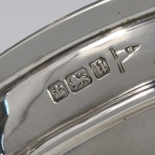 A very handsome and large pair of Antique Sterling Silver bon-bon dishes, having plain round bodies, with applied reeded borders and two scroll side handles, all raised above and sitting on plain round pedestal feet. This elegant pair of silver dishes were made by Walker and Hall of Sheffield  in 1912. The dimensions of these fine hand-made antique silver bon-bon dishes are height 12.5 cms (5 inches), diameter 15 cms (6 inches), and they weigh a total of approx. 520g (16.8 troy ounces).   
