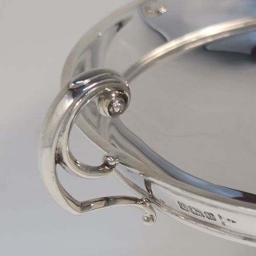 A very handsome and large pair of Antique Sterling Silver bon-bon dishes, having plain round bodies, with applied reeded borders and two scroll side handles, all raised above and sitting on plain round pedestal feet. This elegant pair of silver dishes were made by Walker and Hall of Sheffield  in 1912. The dimensions of these fine hand-made antique silver bon-bon dishes are height 12.5 cms (5 inches), diameter 15 cms (6 inches), and they weigh a total of approx. 520g (16.8 troy ounces).   