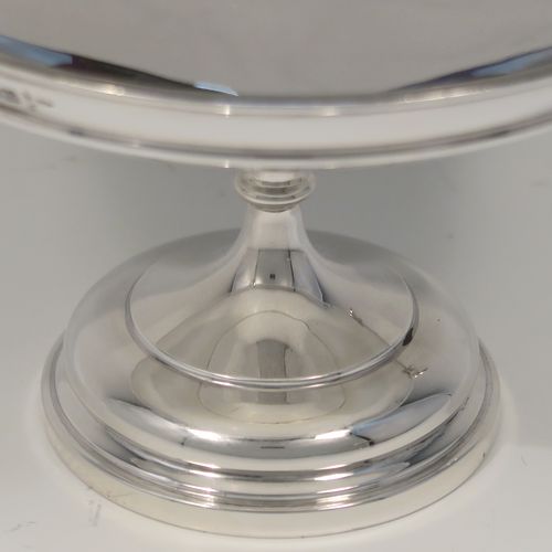 A very handsome and large pair of Antique Sterling Silver bon-bon dishes, having plain round bodies, with applied reeded borders and two scroll side handles, all raised above and sitting on plain round pedestal feet. This elegant pair of silver dishes were made by Walker and Hall of Sheffield  in 1912. The dimensions of these fine hand-made antique silver bon-bon dishes are height 12.5 cms (5 inches), diameter 15 cms (6 inches), and they weigh a total of approx. 520g (16.8 troy ounces).   