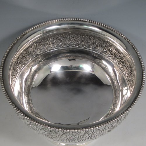Antique Victorian sterling silver large table rose bowl, having a round body with a hand-chased band of floral decoration, an applied bead-edged border, and all sitting on a pedestal foot. Made by Edgar Finlay & Hugh Taylor of Birmingham in 1888. The dimensions of this fine hand-made silver bowl are diameter 24 cms (9.5 inches), height 16 cms (6.25 inches), and it weighs approx. 752g (24 troy ounces).
