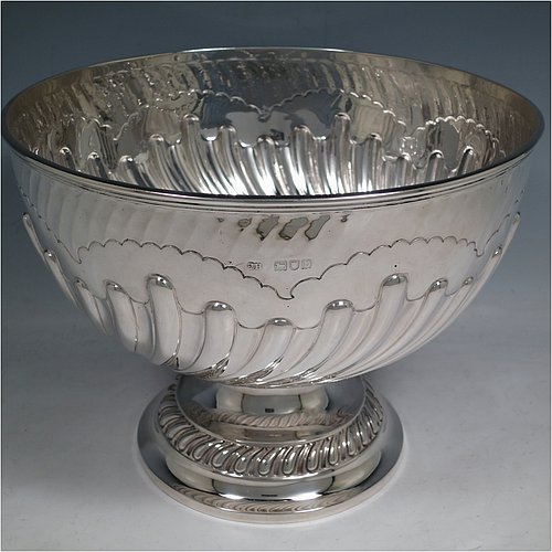 An Antique Victorian Sterling Silver large table bowl, having a round body with an applied reeded border and hand-chased half swirl-fluted decoration, all sitting on a pedestal foot which is also fluted. Made by Sibray, Hall & Co., of London in 1897. The dimensions of this fine hand-made antique silver bowl are diameter 25.5 cms (10 inches), height 19 cms (7.5 inches), and it weighs approx. 1,041g (33.6 troy ounces).   