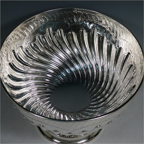 An Antique Victorian Sterling Silver large table bowl, having a round body with an applied reeded border and hand-chased half swirl-fluted decoration, all sitting on a pedestal foot which is also fluted. Made by Sibray, Hall & Co., of London in 1897. The dimensions of this fine hand-made antique silver bowl are diameter 25.5 cms (10 inches), height 19 cms (7.5 inches), and it weighs approx. 1,041g (33.6 troy ounces).
