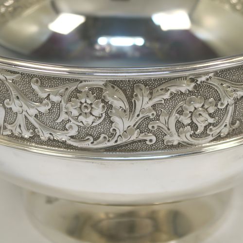 A very pretty antique Victorian Silver Plated table bowl, having a round bellied body with a hand-chased upper band of floral and scroll work with vacant cartouches, with two cast lion-mask ring side-handles, and sitting on a round plain pedestal foot. This beautiful antique silver-plated fruit bowl was made in Sheffield in ca. 1880. The dimensions of this fine hand-made antique silver plated table bowl are diameter 25.5 cms (10inches), and height 16 cms (6.3inches).