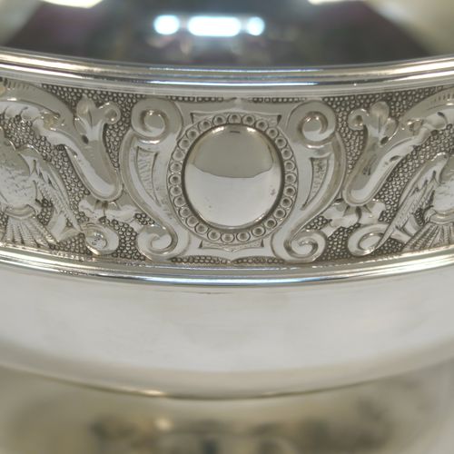A very pretty antique Victorian Silver Plated table bowl, having a round bellied body with a hand-chased upper band of floral and scroll work with vacant cartouches, with two cast lion-mask ring side-handles, and sitting on a round plain pedestal foot. This beautiful antique silver-plated fruit bowl was made in Sheffield in ca. 1880. The dimensions of this fine hand-made antique silver plated table bowl are diameter 25.5 cms (10inches), and height 16 cms (6.3inches).