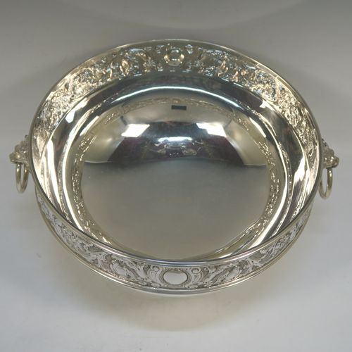 A very pretty antique Victorian Silver Plated table bowl, having a round bellied body with a hand-chased upper band of floral and scroll work with vacant cartouches, with two cast lion-mask ring side-handles, and sitting on a round plain pedestal foot. This beautiful antique silver-plated fruit bowl was made in Sheffield in ca. 1880. The dimensions of this fine hand-made antique silver plated table bowl are diameter 25.5 cms (10inches), and height 16 cms (6.3inches).