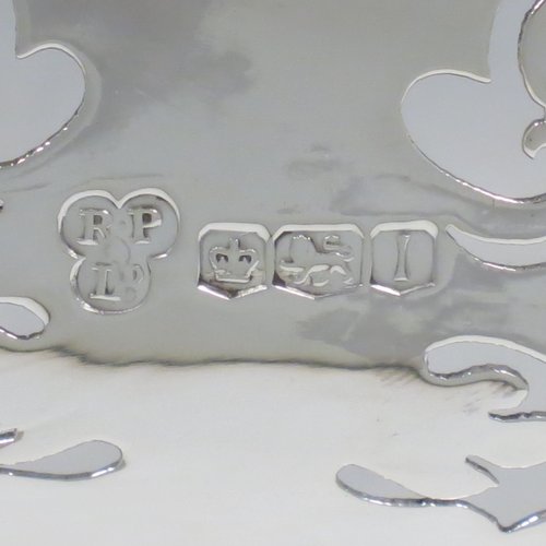 A Sterling Silver large table bowl, having an oval body with hand-pierced floral decoration, an applied cast border with oak-leaf mounts, with two cast loop handles, and all sitting on four cast foliate feet with matching decoration. Made by Robert Pringle of Sheffield in 1951. The dimensions of this fine hand-made silver bowl are length 32 cms (12.5 inches), width 20 cms (8 inches), height 14 cms (5.5 inches), and it weighs approx. 898g (29 troy ounces).