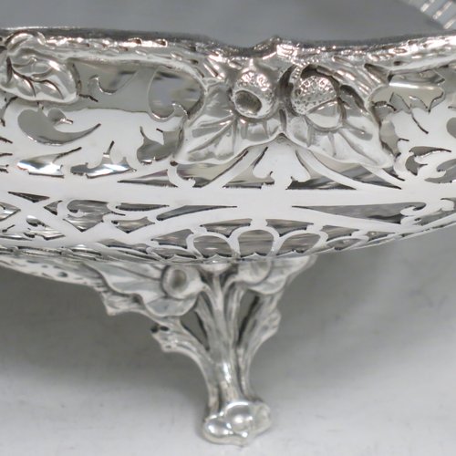A Sterling Silver large table bowl, having an oval body with hand-pierced floral decoration, an applied cast border with oak-leaf mounts, with two cast loop handles, and all sitting on four cast foliate feet with matching decoration. Made by Robert Pringle of Sheffield in 1951. The dimensions of this fine hand-made silver bowl are length 32 cms (12.5 inches), width 20 cms (8 inches), height 14 cms (5.5 inches), and it weighs approx. 898g (29 troy ounces).