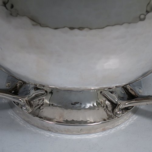 An Antique Edwardian heavy Sterling Silver Art Nouveau style table bowl, having a round hand-hammered and bellied body, with three cast scroll and tendril handles attached to a pedestal foot. Made by the Barker Brothers of Chester in 1909. The dimensions of this fine hand-made antique silver bowl are height 15 cms (6 inches), diameter at top of bowl 20 cms (8 inches), and it weighs approx. 44 troy ounces (1,370g).