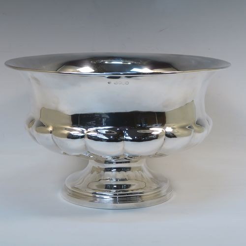 A rare and very elegant Antique late Georgian Sterling Silver large table bowl, having a round bellied body with a lower band of hand-chased melon-style fluting, and all sitting on a round pedestal foot. This beautiful antique silver table bowl was made by Joseph Cradock of London in 1828. The dimensions of this fine hand-made antique silver bowl are diameter 30.5 cms (12 inches), height 18.5 cms (7.3 inches), and it weighs approx. 1,222g (39.4 troy ounces).