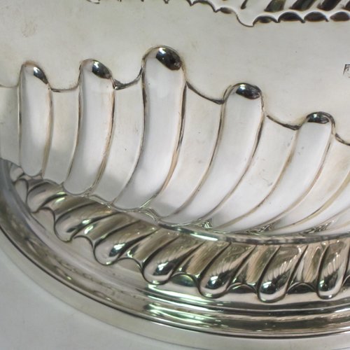 Antique Victorian sterling silver large Rose bowl, having a round body with hand-chased half swirl-fluted decoration, an applied reeded rim above another band of hand-chased fluting, and sitting on a pedestal foot with matching fluting. Made by Lamberts of London in 1893. The dimensions of this fine hand-made silver large table bowl are diameter 35 cms (13.75 inches), height 21 cms (8.25 inches), and it weighs approx. 1,767g (57 troy ounces).