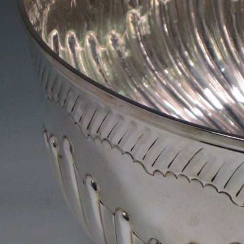 Antique Victorian sterling silver large Rose bowl, having a round body with hand-chased half swirl-fluted decoration, an applied reeded rim above another band of hand-chased fluting, and sitting on a pedestal foot with matching fluting. Made by Lamberts of London in 1893. The dimensions of this fine hand-made silver large table bowl are diameter 35 cms (13.75 inches), height 21 cms (8.25 inches), and it weighs approx. 1,767g (57 troy ounces).