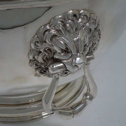 A very handsome and large Antique Edwardian Sterling Silver Montieth style bowl, having a plain round body with an applied scroll border, together with two cast lion-mask side-handles, and sitting on a pedestal foot. Made by William Comyns of London in 1902. The dimensions of this fine hand-made antique silver Montieth table bowl are diameter 31 cms (12 inches), height 23 cms (9 inches), and it weighs approx. 2,440g (78.7 troy ounces).