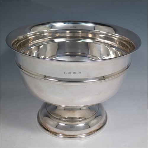 A Sterling Silver table bowl, having a round plain body, with an applied central band, and sitting on a matching pedestal foot. Made in Birmingham in 1930. The dimensions of this fine hand-made silver bowl are diameter 24 cms (9.5 inches), height 18.5 cms (7.25 inches), and it weighs approx. 807g (26 troy ounces).    