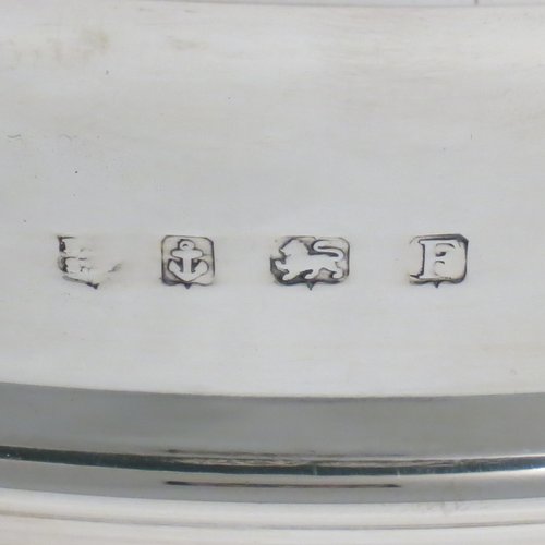 A Sterling Silver table bowl, having a round plain body, with an applied central band, and sitting on a matching pedestal foot. Made in Birmingham in 1930. The dimensions of this fine hand-made silver bowl are diameter 24 cms (9.5 inches), height 18.5 cms (7.25 inches), and it weighs approx. 807g (26 troy ounces).