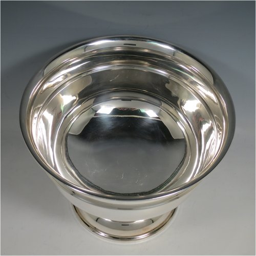 A Sterling Silver table bowl, having a round plain body, with an applied central band, and sitting on a matching pedestal foot. Made in Birmingham in 1930. The dimensions of this fine hand-made silver bowl are diameter 24 cms (9.5 inches), height 18.5 cms (7.25 inches), and it weighs approx. 807g (26 troy ounces).