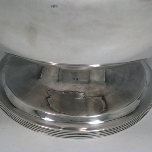 Antique Georgian sterling silver very rare large table bowl, having a plain round body, applied reeded borders, and sitting on a pedestal foot. Made by Thomas Howell of London in 1797, with an extra makers mark on the body. Height 18 cms (7 inches), diameter 25.5 cms (10 cms). Weight approx. 1,092g (35.2 troy ounces).