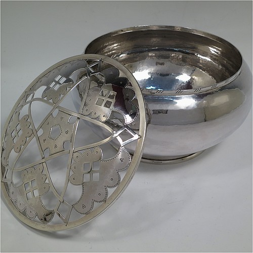 A very unusual and pretty Sterling Silver rose bowl in a a plain round bellied style with hand-hammered decoration finish, an original hand-pierced lift-off removable rose-grill, and all sitting on a collet foot base. Made by the London Assay Office of London in 1975. The dimensions of this fine hand-made silver rose bowl and grill are height 13.5 cms (5.25 inches), diameter 24 cms (9.5 inches), and it weighs approx. 1,195g (38.5 troy ounces).