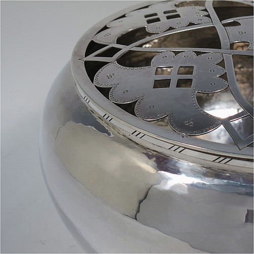 A very unusual and pretty Sterling Silver rose bowl in a a plain round bellied style with hand-hammered decoration finish, an original hand-pierced lift-off removable rose-grill, and all sitting on a collet foot base. Made by the London Assay Office of London in 1975. The dimensions of this fine hand-made silver rose bowl and grill are height 13.5 cms (5.25 inches), diameter 24 cms (9.5 inches), and it weighs approx. 1,195g (38.5 troy ounces).