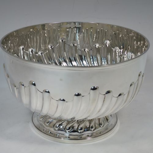 A very nice quality Antique Victorian Sterling Silver Rose bowl, having a round body with hand-chased half swirl-fluted decoration, an applied reeded rim, and sitting on a pedestal foot with matching fluting. Made by John Frank Hall of London in 1895. The dimensions of this fine hand-made antique silver rose bowl are diameter 26 cms (10.25 inches), height 16 cms (6.25 inches), and it weighs approx. 945g (30 troy ounces).