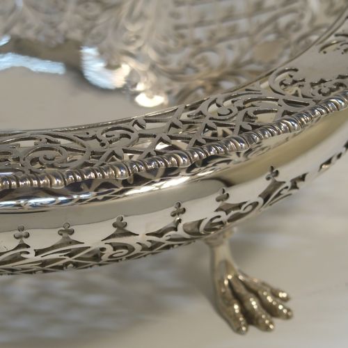 A very pretty Antique Sterling Silver fruit bowl, having a round body with hand-pierced floral and scroll decoration, an applied gadroon top border, and all sitting on three cast lions-paw feet. This beautiful silver fruit bowl was made by James Dixon and Sons of Sheffield in 1912. The dimensions of this fine hand-made antique silver fruit bowl are diameter 25.5 cms (10 inches), height 8 cms (3.25 inches), and it weighs approx. 772g (25 troy ounces).