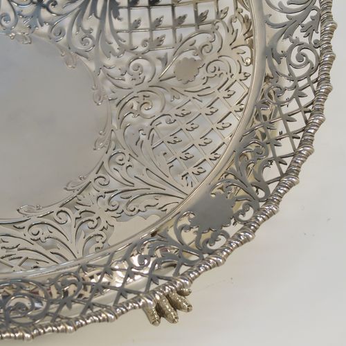A very pretty Antique Sterling Silver fruit bowl, having a round body with hand-pierced floral and scroll decoration, an applied gadroon top border, and all sitting on three cast lions-paw feet. This beautiful silver fruit bowl was made by James Dixon and Sons of Sheffield in 1912. The dimensions of this fine hand-made antique silver fruit bowl are diameter 25.5 cms (10 inches), height 8 cms (3.25 inches), and it weighs approx. 772g (25 troy ounces).