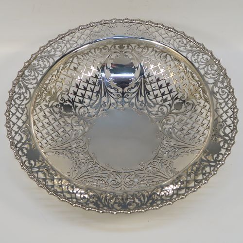 A very pretty Antique Sterling Silver fruit bowl, having a round body with hand-pierced floral and scroll decoration, an applied gadroon top border, and all sitting on three cast lions-paw feet. This beautiful silver fruit bowl was made by James Dixon and Sons of Sheffield in 1912. The dimensions of this fine hand-made antique silver fruit bowl are diameter 25.5 cms (10 inches), height 8 cms (3.25 inches), and it weighs approx. 772g (25 troy ounces).