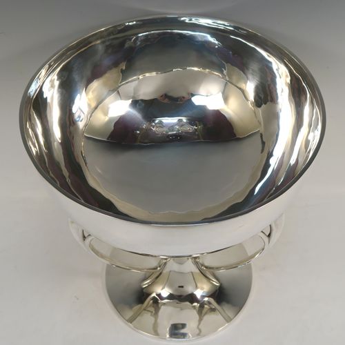 A very handsome Scottish Antique Sterling Silver Art Nouveau style table bowl, having a plain round and bellied body, with three cast scroll and tendril supports attached to a pedestal foot with a central finial. This elegant silver table bowl was made by David and George Edward of Glasgow in 1915. The dimensions of this fine hand-made Art Nouveau Scottish silver bowl are height 27 cms (10.5 inches), diameter at top of bowl 25.5 cms (10 inches), and it weighs approx. 1,535g (49.5 troy ounces).