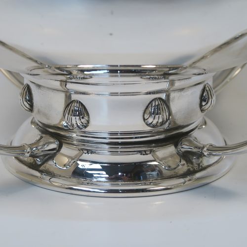 A very handsome Sterling Silver Art Deco style table bowl, having a plain round and bellied body, with four cast scroll supports attached to a pedestal foot with a central girdle of applied shell motifs. This elegant silver table bowl was made by James Ogden and Sons of Birmingham in 1934. The dimensions of this fine hand-made Art Deco silver bowl are height 15 cms (6 inches), diameter at top of bowl 20 cms (8 inches), and it weighs approx. 918g (29.6 troy ounces).