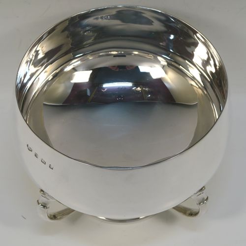A very handsome Sterling Silver Art Deco style table bowl, having a plain round and bellied body, with four cast scroll supports attached to a pedestal foot with a central girdle of applied shell motifs. This elegant silver table bowl was made by James Ogden and Sons of Birmingham in 1934. The dimensions of this fine hand-made Art Deco silver bowl are height 15 cms (6 inches), diameter at top of bowl 20 cms (8 inches), and it weighs approx. 918g (29.6 troy ounces).