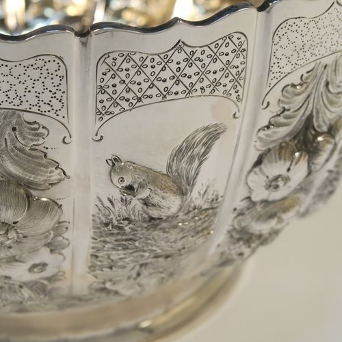 A very unusual and beautiful Antique Victorian Sterling Silver large Rose bowl, having a round panelled body with hand-chased floral and figural decoration, a wavy-edge top border and a gold-gilt interior, and all sitting on a round pedestal foot. This amazing antique silver bowl was made by Francis Boone Thomas of London in 1899. The dimensions of this fine hand-made antique silver large table bowl are diameter 30 cms (11.75 inches), height 17cms (6.75 inches), and it weighs approx. 1,286g (41.5 troy ounces).   