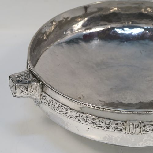 A very unusual and beautiful Antique Sterling Silver Art and Crafts style table bowl, having a round bellied body with hand-hammered decoration, an applied rope-twist top border, together with an applied central band of leaf design work, with three matching side-handles, and all sitting on a pedestal foot. This superb Arts and Crafts style silver table bowl was made by John Sydney Reeve of Birmingham in 1912. The dimensions of this fine hand-made antique silver bowl are height 8.5 cms (3.3 inches), diameter at top of bowl 24 cms (9.5 inches), and it weighs approx. 799g (25.8 troy ounces).