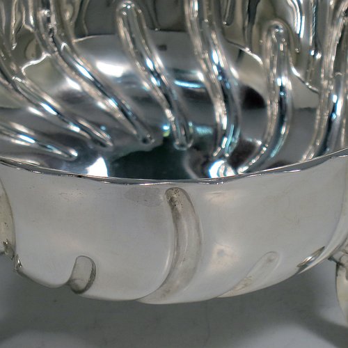 An Antique Victorian Sterling Silver bowl, having a round body, with hand-chased swirl half-fluting, a shaped pie-crust border, and all sitting on three cast hoof feet with shell shoulders. Made by the Barnard Brothers of London in 1888. The dimensions of this fine hand-made antique silver bowl are height 7 cms (2.75 inches), diameter 13 cms (5.25 inches), and it weighs approx. 195g (6.3 troy ounces).