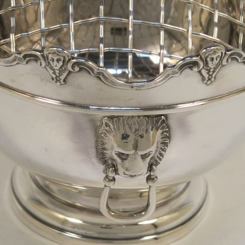 A handsome pair of Antique Edwardian Sterling Silver Monteith style bowls with rose grills, having round bodies with applied scroll borders, with cast lion-mask handles either side, and all sitting on pedestal feet. These elegant silver rose bowls were made by Jays of Chester in 1906. The dimensions of these fine hand-made antique silver Montieth rose bowls are diameter 14 cms (5.5 inches), height 11 cms (4.25 inches), and they weigh a total of approx. 800g (25.8 troy ounces). Please note that this item is part-crested.