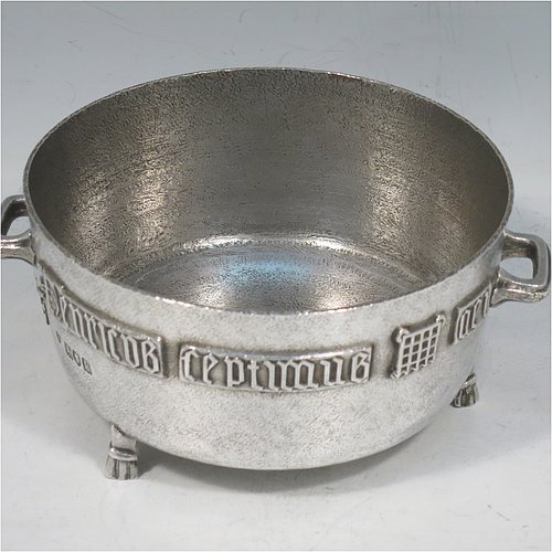 An Antique Edwardian Sterling Silver Arts & Crafts style bowl, being a copy of the Winchester Bushel measure, having a round straight-sided body with a hand-hammered finish, an applied inscription on both sides, with two cast handles, and sitting on four cast feet. Made by the Barnard Brothers of London in 1905. The dimensions of this fine hand-made antique silver bowl are height 8 cms (2.3 inches), diameter 11.5 cms (4.5 inches), and it weighs approx. 325g (10.5 troy ounces).