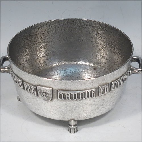 An Antique Edwardian Sterling Silver Arts & Crafts style bowl, being a copy of the Winchester Bushel measure, having a round straight-sided body with a hand-hammered finish, an applied inscription on both sides, with two cast handles, and sitting on four cast feet. Made by the Barnard Brothers of London in 1905. The dimensions of this fine hand-made antique silver bowl are height 8 cms (2.3 inches), diameter 11.5 cms (4.5 inches), and it weighs approx. 325g (10.5 troy ounces).