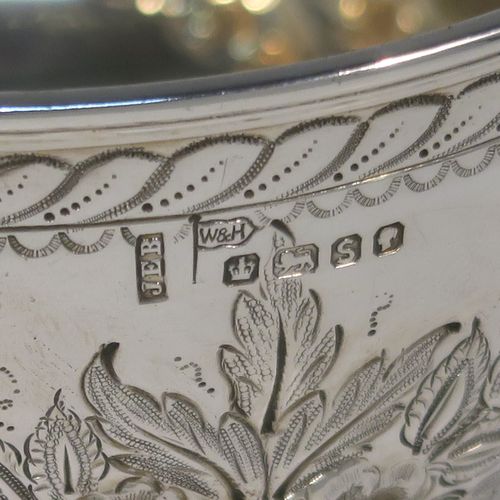 A very pretty Antique Victorian Sterling Silver rose bowl, having a round body with hand-chased swags of floral decoration surrounding two vacant round cartouches on either side, with an applied reed-edged border, a gold-gilt interior, and all sitting on a plain round pedestal foot. This beautiful silver bowl was made by Walker and Hall of Sheffield in 1885. The dimensions of this fine hand-made antique silver bowl are diameter 11 cms (4.25 inches), height 8 cms (3 inches), and it weighs approx. 134g (4.3 troy ounces).