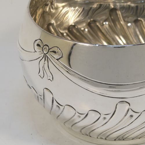 A very pretty Antique Victorian Sterling Silver small Rose bowl, having a round bellied body with hand-chased bows, swags, and half swirl-fluted decoration, and sitting on a flat base. This beautiful antique silver rose bowl was made by the Barnard Brothers of London in 1896. The dimensions of this fine hand-made silver bowl are height 7.5 cms (3 inches), diameter 12 cms (4.75 inches), and it weighs approx. 220g (7 troy ounces).