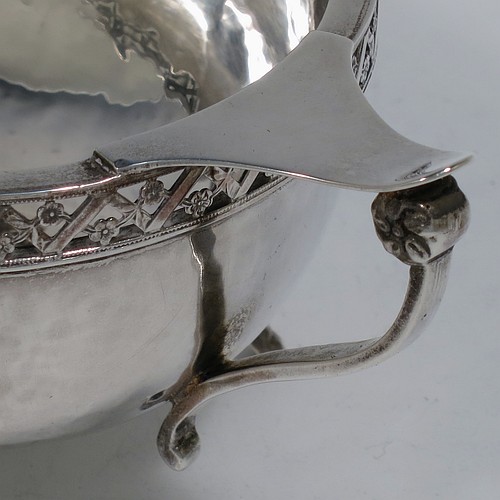 A very unusual and pretty pair of Arts and Crafts style Sterling Silver bowls, having oval bodies with hand-hammered decoration, with hand-pierced and floral borders, two scroll side-handles with flat thumb-pieces, and all sitting on four cast goat hoof feet. Made by A. E. Jones of Birmingham in 1921. The dimensions of these fine hand-made Arts and Crafts silver oval bowls are length 21 cms (8.25 inches), width 11 cms (4.3 inches), height 6.5 cms (2.5 inches), and they weigh a total of approx. 470g (15.2 troy ounces).