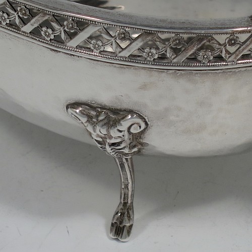 A very unusual and pretty pair of Arts and Crafts style Sterling Silver bowls, having oval bodies with hand-hammered decoration, with hand-pierced and floral borders, two scroll side-handles with flat thumb-pieces, and all sitting on four cast goat hoof feet. Made by A. E. Jones of Birmingham in 1921. The dimensions of these fine hand-made Arts and Crafts silver oval bowls are length 21 cms (8.25 inches), width 11 cms (4.3 inches), height 6.5 cms (2.5 inches), and they weigh a total of approx. 470g (15.2 troy ounces).