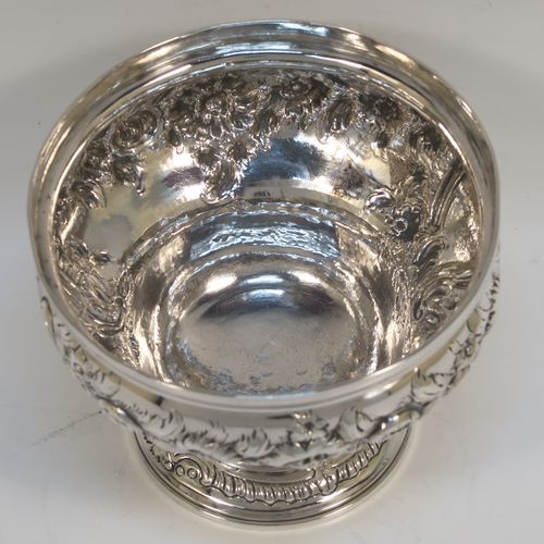 A rare and very pretty Antique Georgian George II Sterling Silver small rose bowl, having a round body with hand-chased floral decoration surrounding two cartouches on either side, and sitting on a round pedestal foot. This beautiful antique silver bowl was made by Thomas Whipham and Charles Wright of London in 1758. The dimensions of this fine hand-made antique silver rose bowl are height 9.5 cms (3.75 inches), diameter 12.5 cms (5 inches), with a weight of approx. 271g (8.7 troy ounces). Please note that one of the cartouches is engraved with a contemporaneous set of initials.