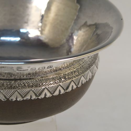 An Arts and Crafts style Sterling Silver & wood Mazer bowl, having a plain round plenished or hand-hammered body, mounted on an Oak base, and having an applied central Celtic style band. This beautiful silver Mazer bowl was made by A. E. Jones of Birmingham in 1928. The dimensions of this fine hand-made wood & silver Mazer bowl are diameter 14 cms (5.5 inches), and height 6.5 cms (2.5 inches). We cannot give a total weight because of the wooden base, but the gauge of silver used is very good.