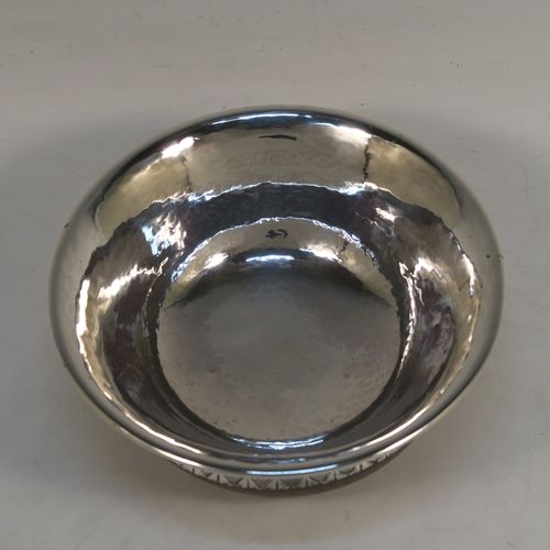 An Arts and Crafts style Sterling Silver & wood Mazer bowl, having a plain round plenished or hand-hammered body, mounted on an Oak base, and having an applied central Celtic style band. This beautiful silver Mazer bowl was made by A. E. Jones of Birmingham in 1928. The dimensions of this fine hand-made wood & silver Mazer bowl are diameter 14 cms (5.5 inches), and height 6.5 cms (2.5 inches). We cannot give a total weight because of the wooden base, but the gauge of silver used is very good.
