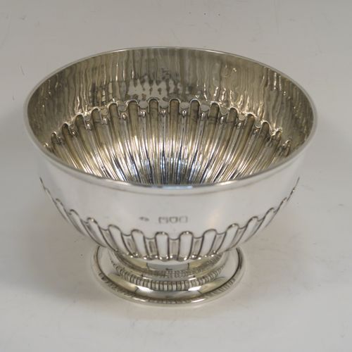 A very handsome Antique Victorian Sterling Silver small Rose bowl, having a round body with hand-chased half-fluted decoration, an applied reeded top border, and sitting on a round pedestal foot. This elegant antique silver rose bowl was made by Frederick Burridge of London in 1898. The dimensions of this fine hand-made silver bowl are height 8.5 cms (3.3 inches), diameter 13.5 cms (5.3 inches), and it weighs approx. 178g (5.7 troy ounces).   