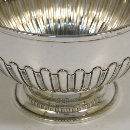 A very handsome Antique Victorian Sterling Silver small Rose bowl, having a round body with hand-chased half-fluted decoration, an applied reeded top border, and sitting on a round pedestal foot. This elegant antique silver rose bowl was made by Frederick Burridge of London in 1898. The dimensions of this fine hand-made silver bowl are height 8.5 cms (3.3 inches), diameter 13.5 cms (5.3 inches), and it weighs approx. 178g (5.7 troy ounces).