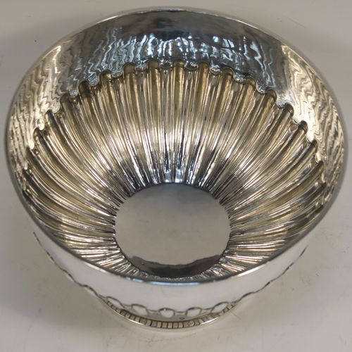 A very handsome Antique Victorian Sterling Silver small Rose bowl, having a round body with hand-chased half-fluted decoration, an applied reeded top border, and sitting on a round pedestal foot. This elegant antique silver rose bowl was made by Frederick Burridge of London in 1898. The dimensions of this fine hand-made silver bowl are height 8.5 cms (3.3 inches), diameter 13.5 cms (5.3 inches), and it weighs approx. 178g (5.7 troy ounces).