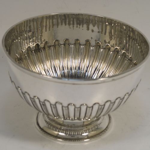 A very handsome Antique Victorian Sterling Silver small Rose bowl, having a round body with hand-chased half-fluted decoration, an applied reeded top border, and sitting on a round pedestal foot. This elegant antique silver rose bowl was made by Frederick Burridge of London in 1898. The dimensions of this fine hand-made silver bowl are height 8.5 cms (3.3 inches), diameter 13.5 cms (5.3 inches), and it weighs approx. 178g (5.7 troy ounces).
