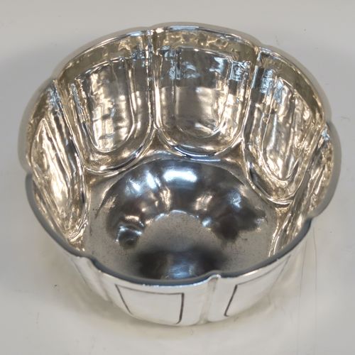 A heavy and handsome Antique Edwardian Sterling Silver small bowl, having a round bellied body with a hand-hammered finish, together with hand-chased panel decoration, and all sitting on a concave base. This elegant antique silver bowl was made by the William Comyns of London in 1904. The dimensions of this fine hand-made silver bowl are height 5 cms (2 inches), diameter 10 cms (4 inches), and it weighs approx. 222g (7.2 troy ounces).