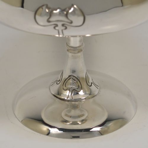 A very pretty Antique Edwardian Sterling Silver Arts & Crafts style bowl, having a round bellied body with hand-chased Lilly style decoration, and sitting on a matching round pedestal foot. This beautiful raised table bowl was made by A. and J. Zimmerman of Birmingham in 1904. The dimensions of this fine hand-made antique silver bowl are height 11 cms (4.3 inches), diameter 13 cms (5 inches), and it weighs approx. 171g (5.5 troy ounces).