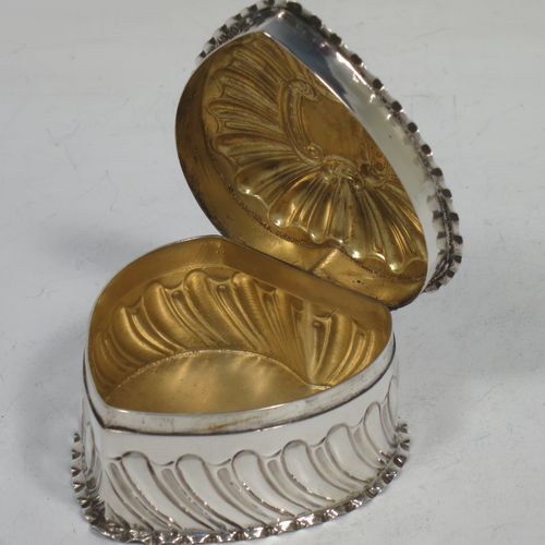A very pretty Antique Victorian Sterling Silver heart-shaped table box, having a gold-gilt interior, all hand-chased with scroll-work, a hinged lid with vacant cartouche, and all sitting on a flat base. Made by Streeter and Co. Ltd., of London in 1899. The dimensions of this fine hand-made antique silver box are length 6 cms (2.3 inches), width 6 cms (2.3 inches), height 4 cms (1.5 inches), and it weighs approx. 49g (1.6 troy ounces).